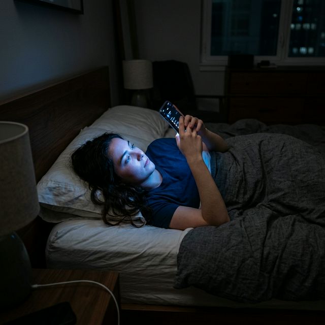 Person using phone in bed